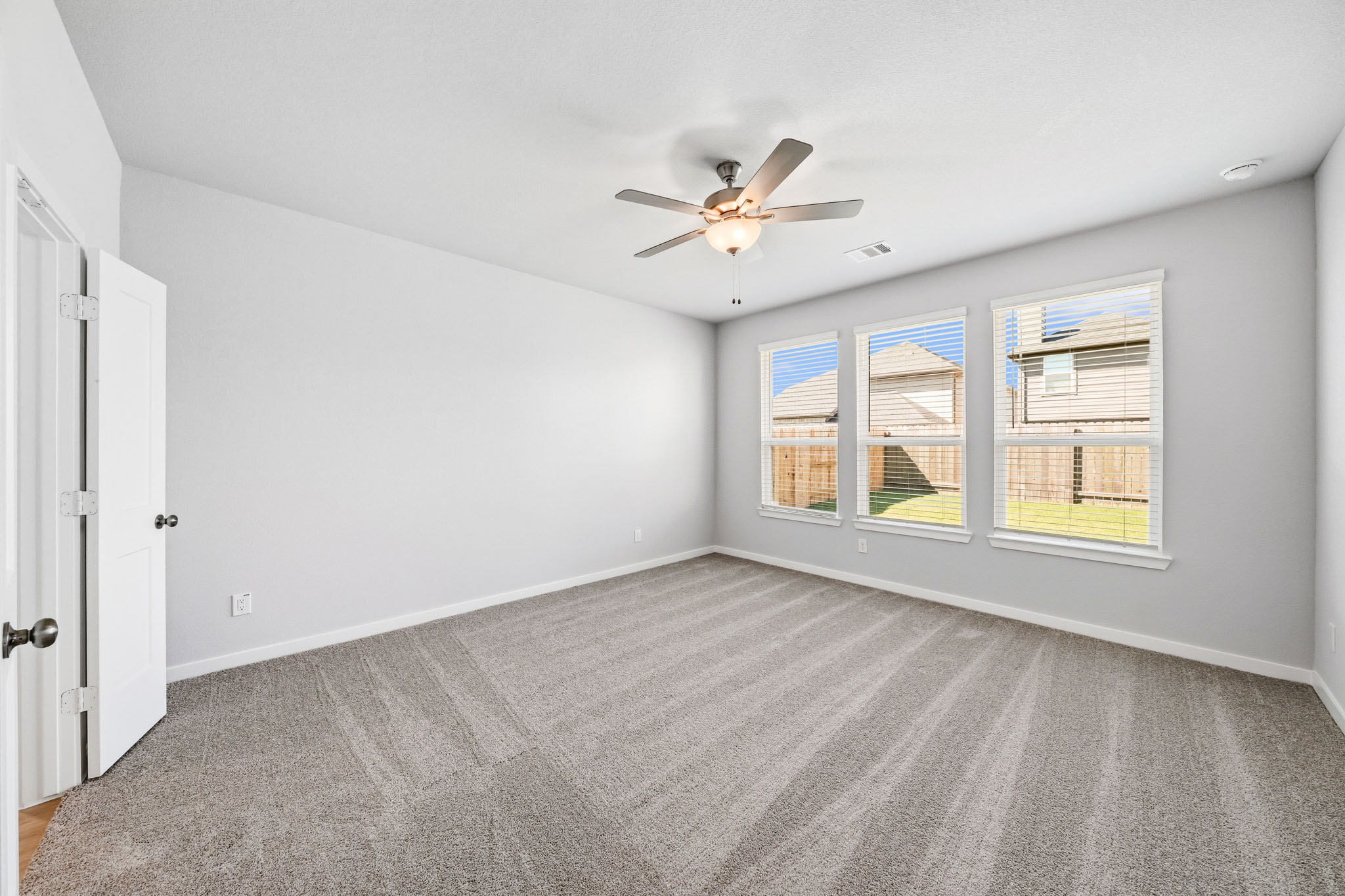 A room with a ceiling fan and a window.