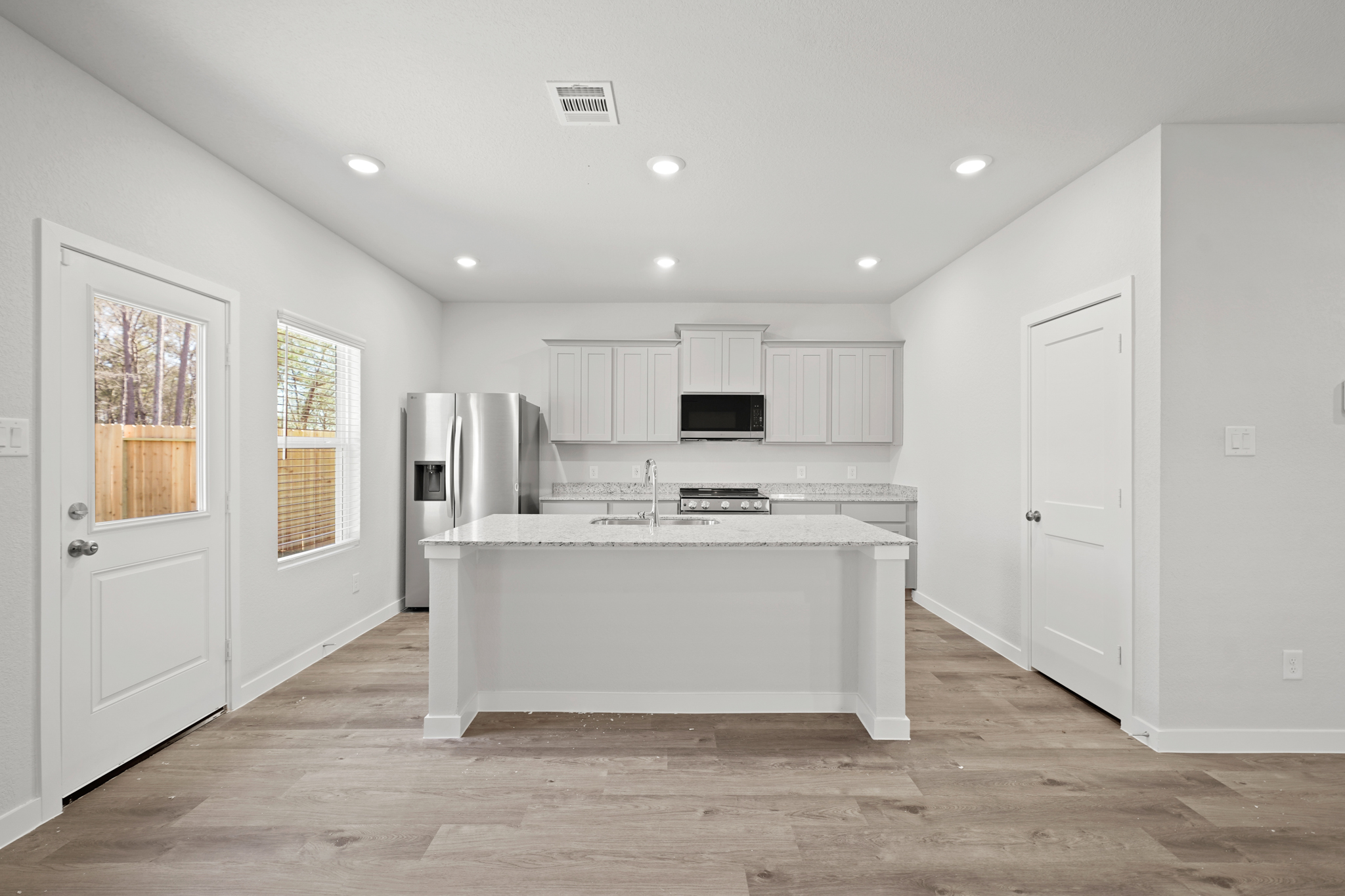 A kitchen with white cabinets.
