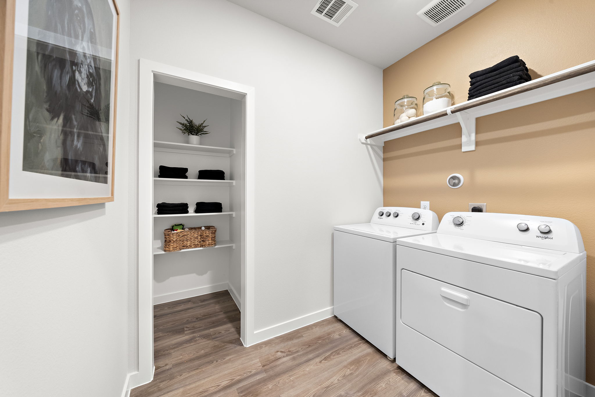 A white room with a shelf and a white cabinet.