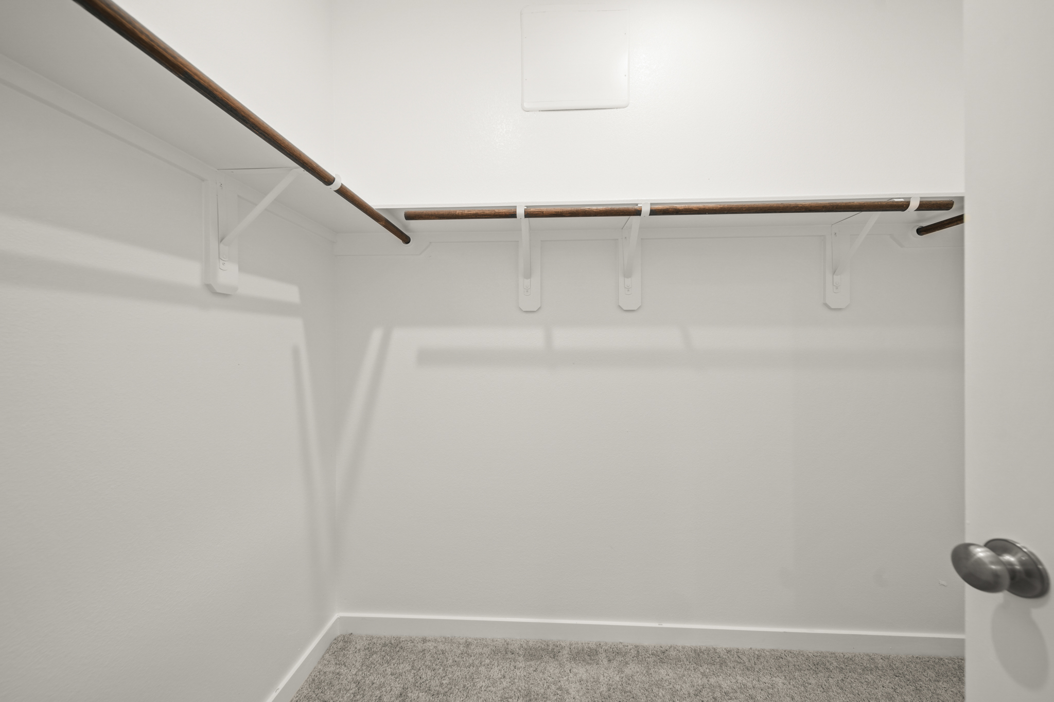 A white wall with a metal bar.