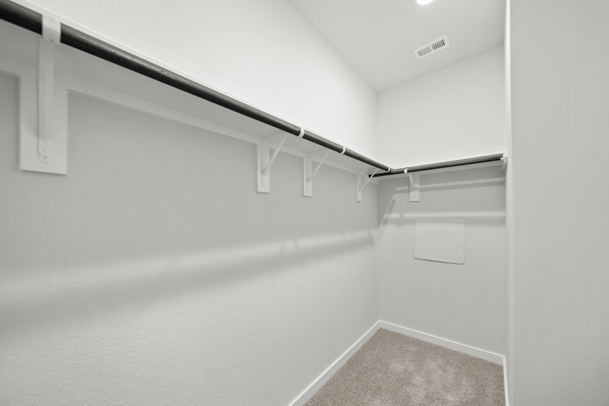 A white hallway with a metal railing.