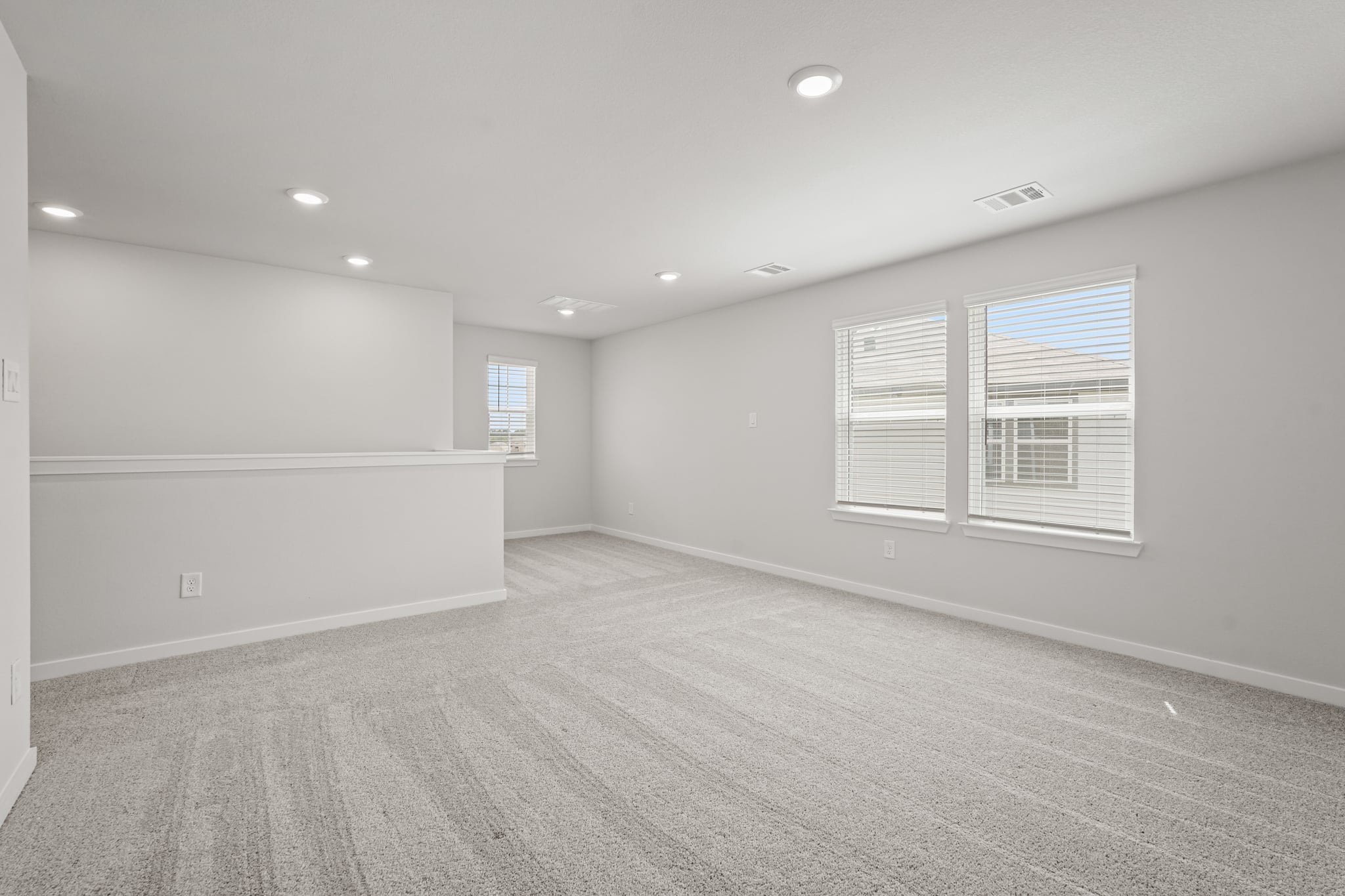 A room with a white wall and windows.