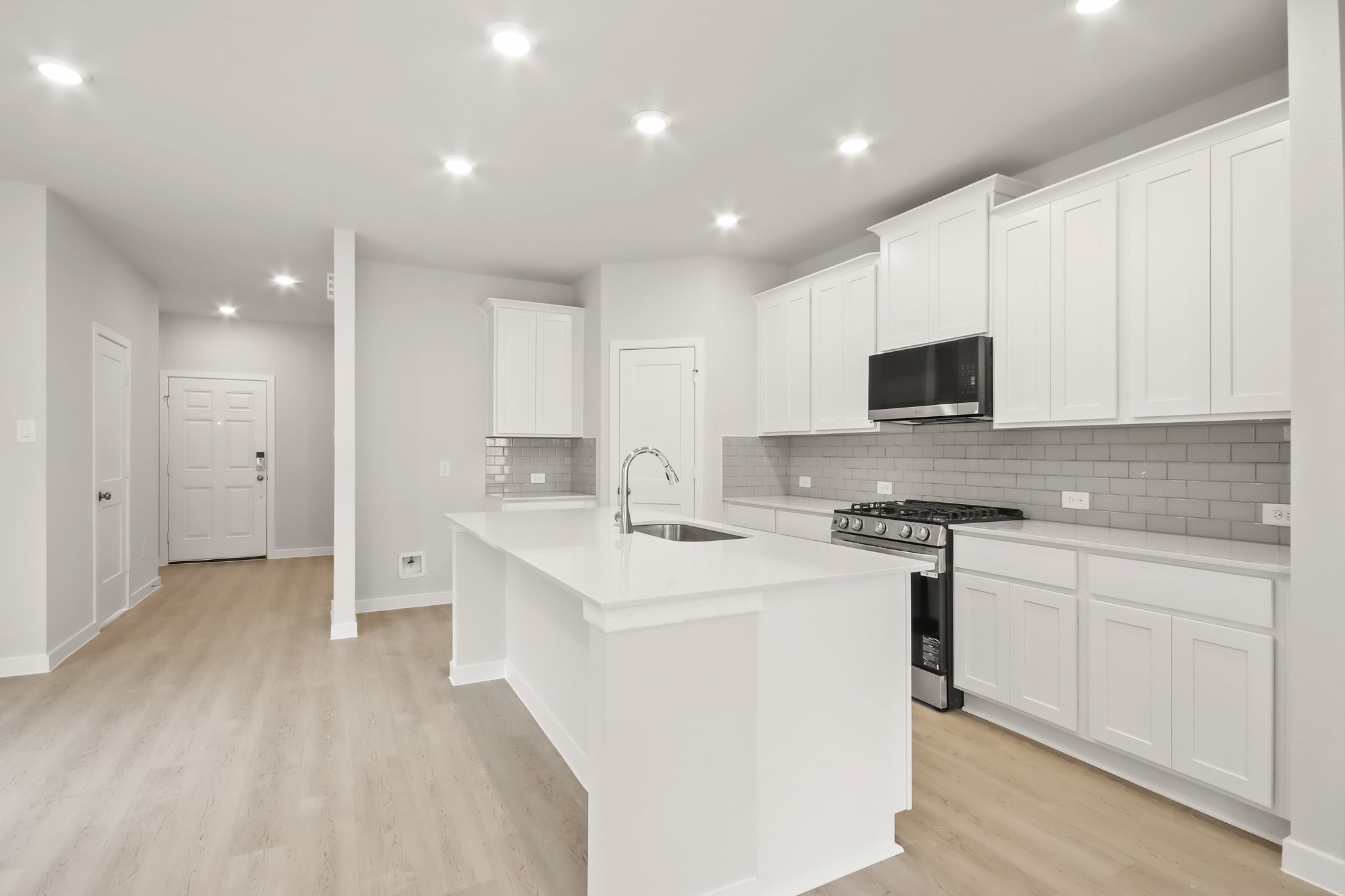 A kitchen with white cabinets.
