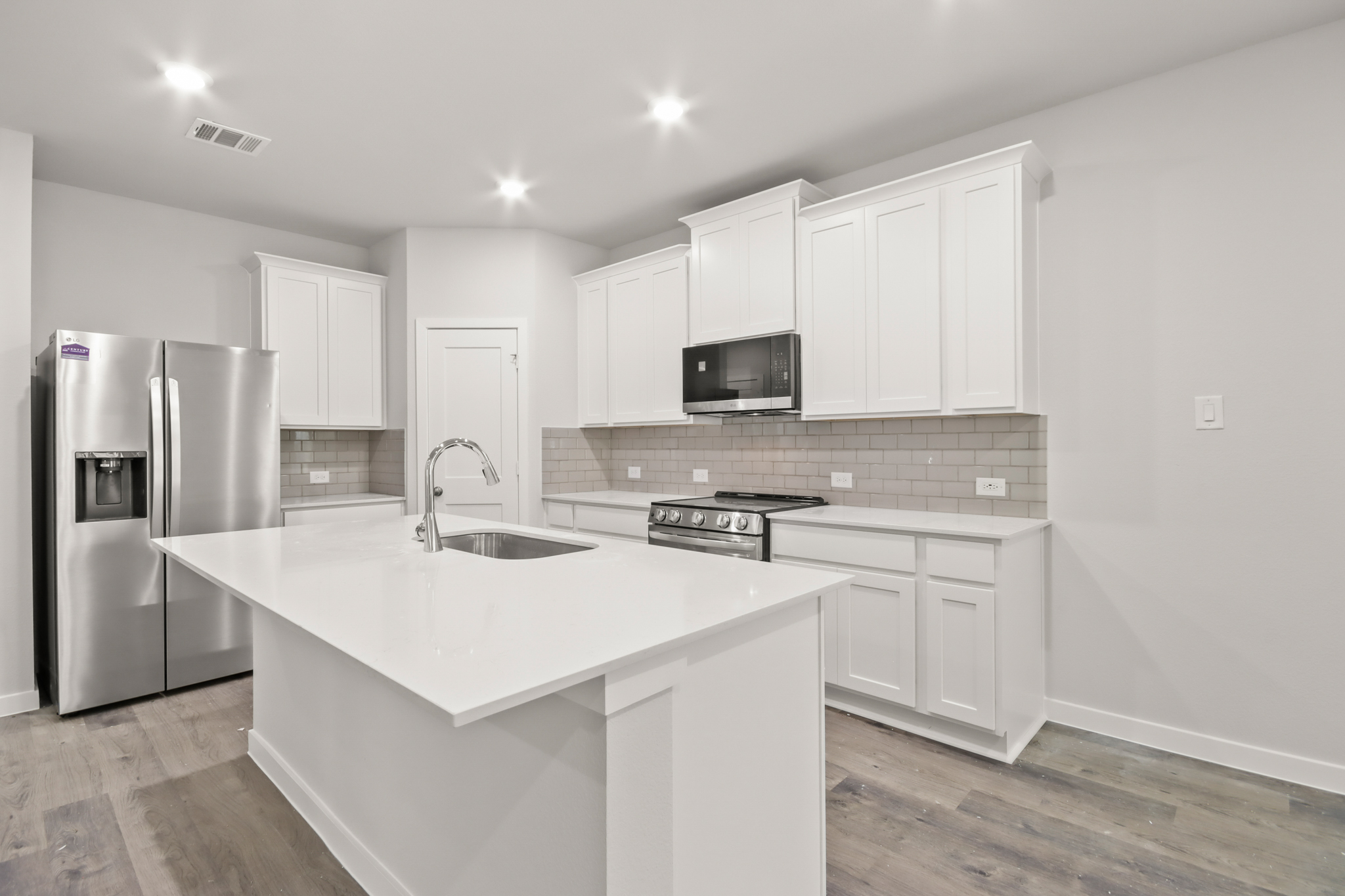 A kitchen with white cabinets.