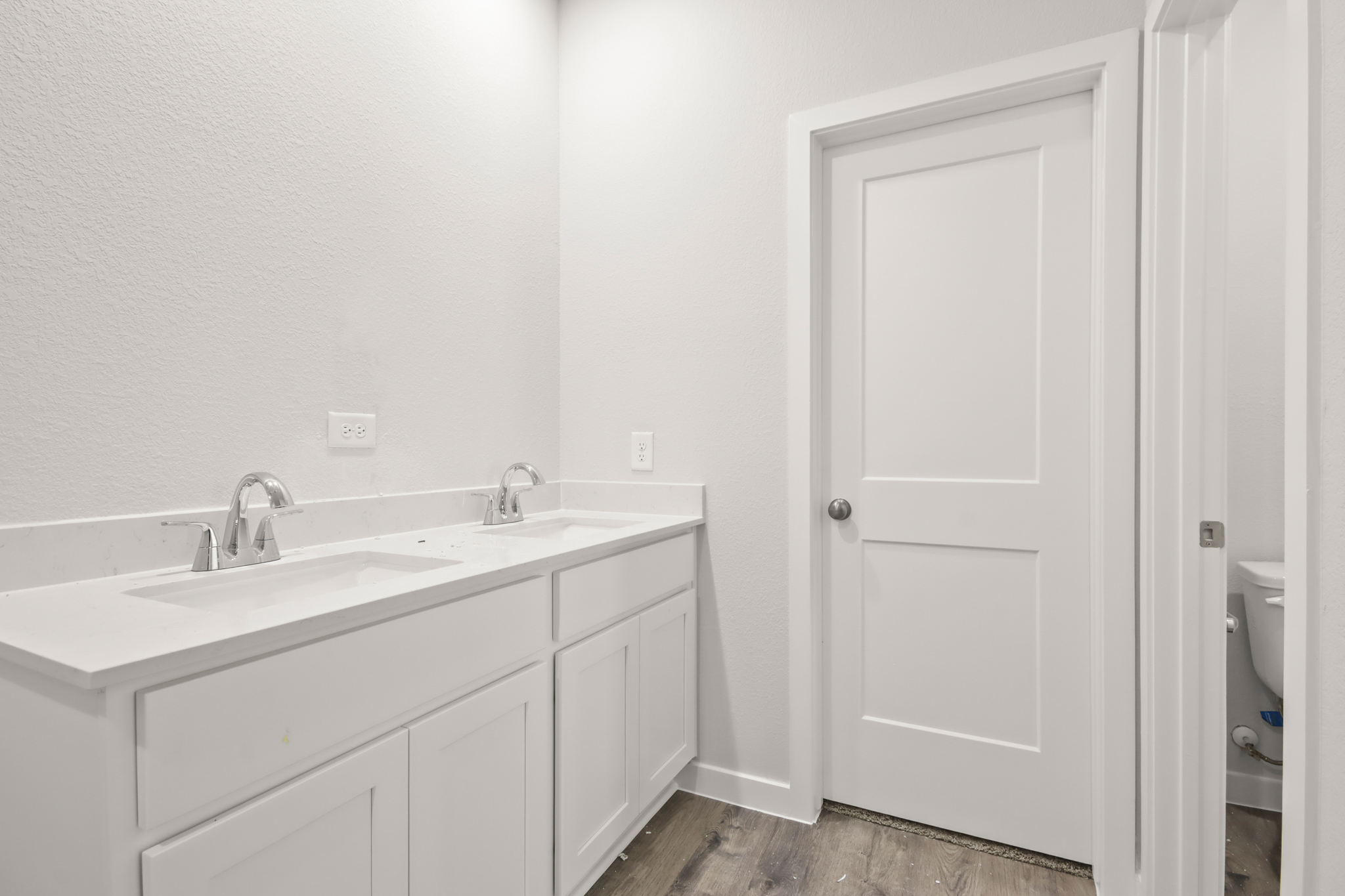 A bathroom with white cabinets.
