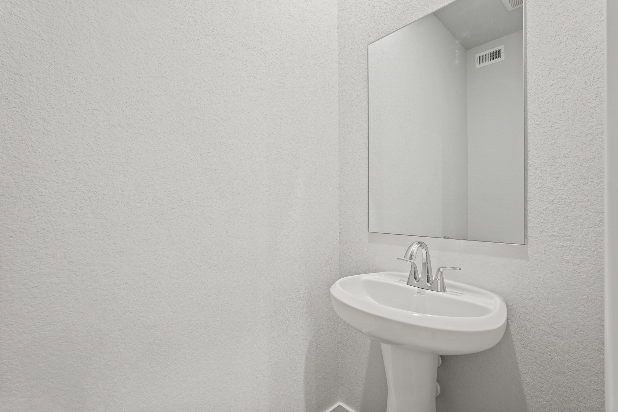 A bathroom with a mirror and sink.