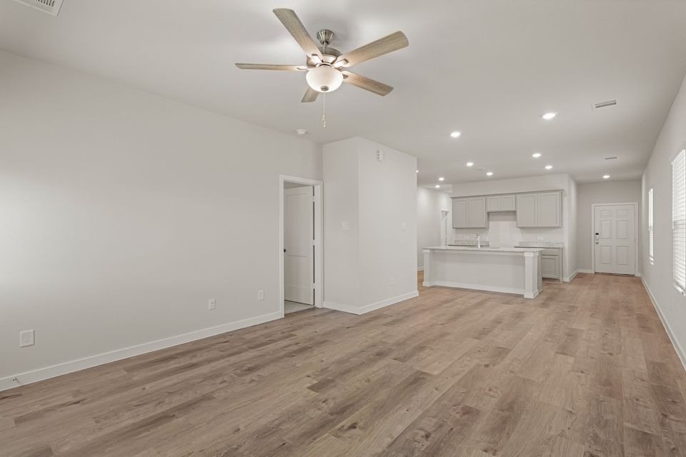 A room with a wood floor and a ceiling fan.