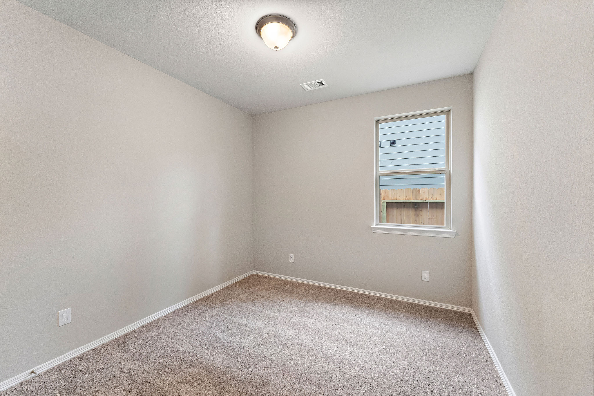 A room with a carpet and a window.