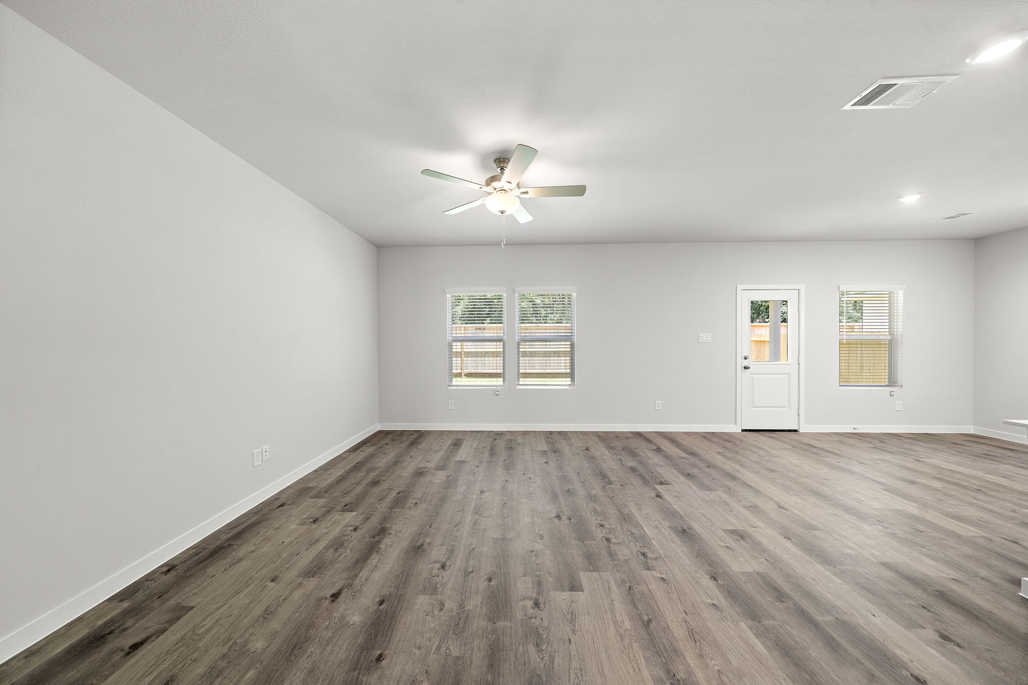 A room with a wood floor and a ceiling fan.