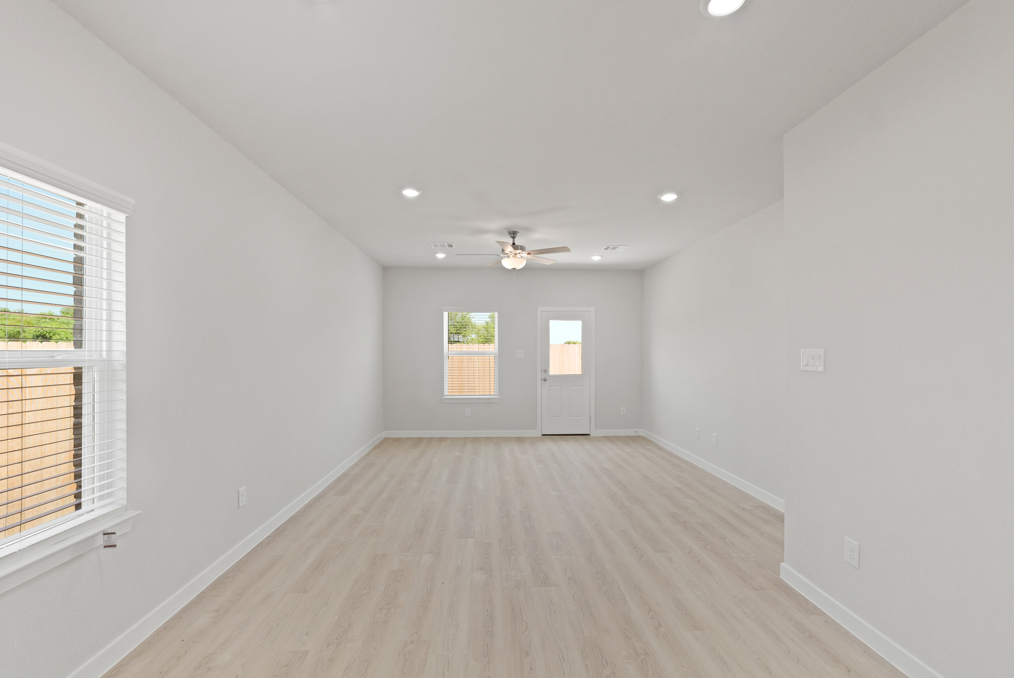 A room with a wood floor and a ceiling fan.