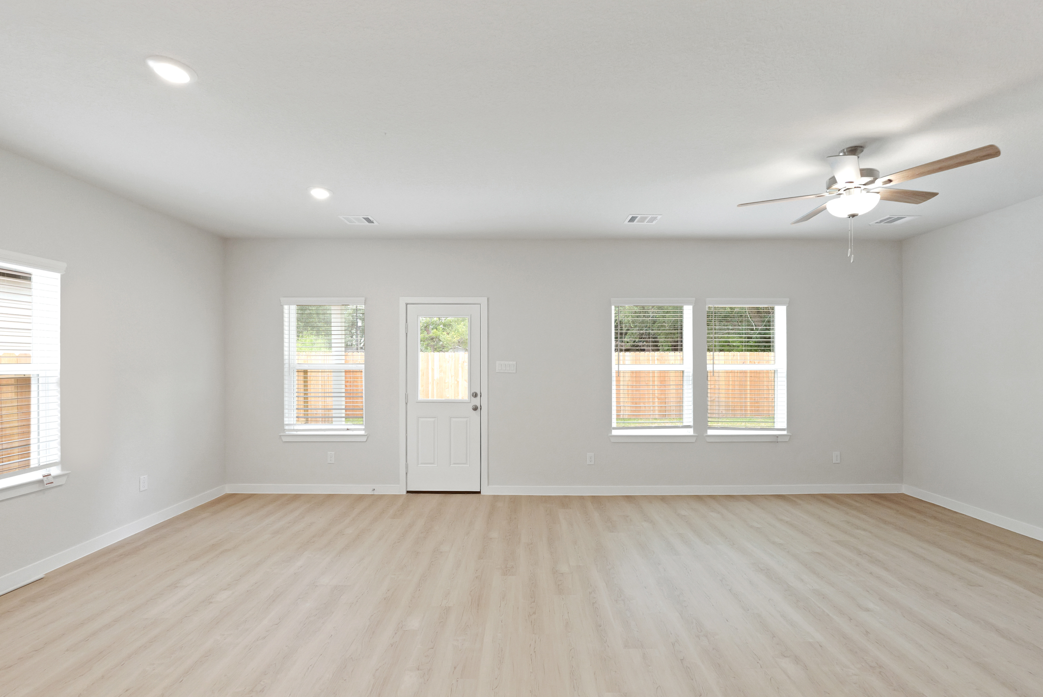 A room with a wood floor and a ceiling fan.