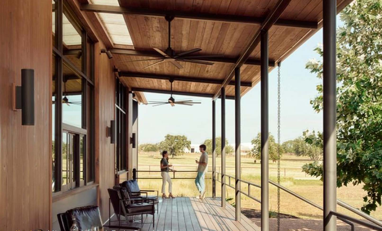 A couple of people walking on a wooden porch.