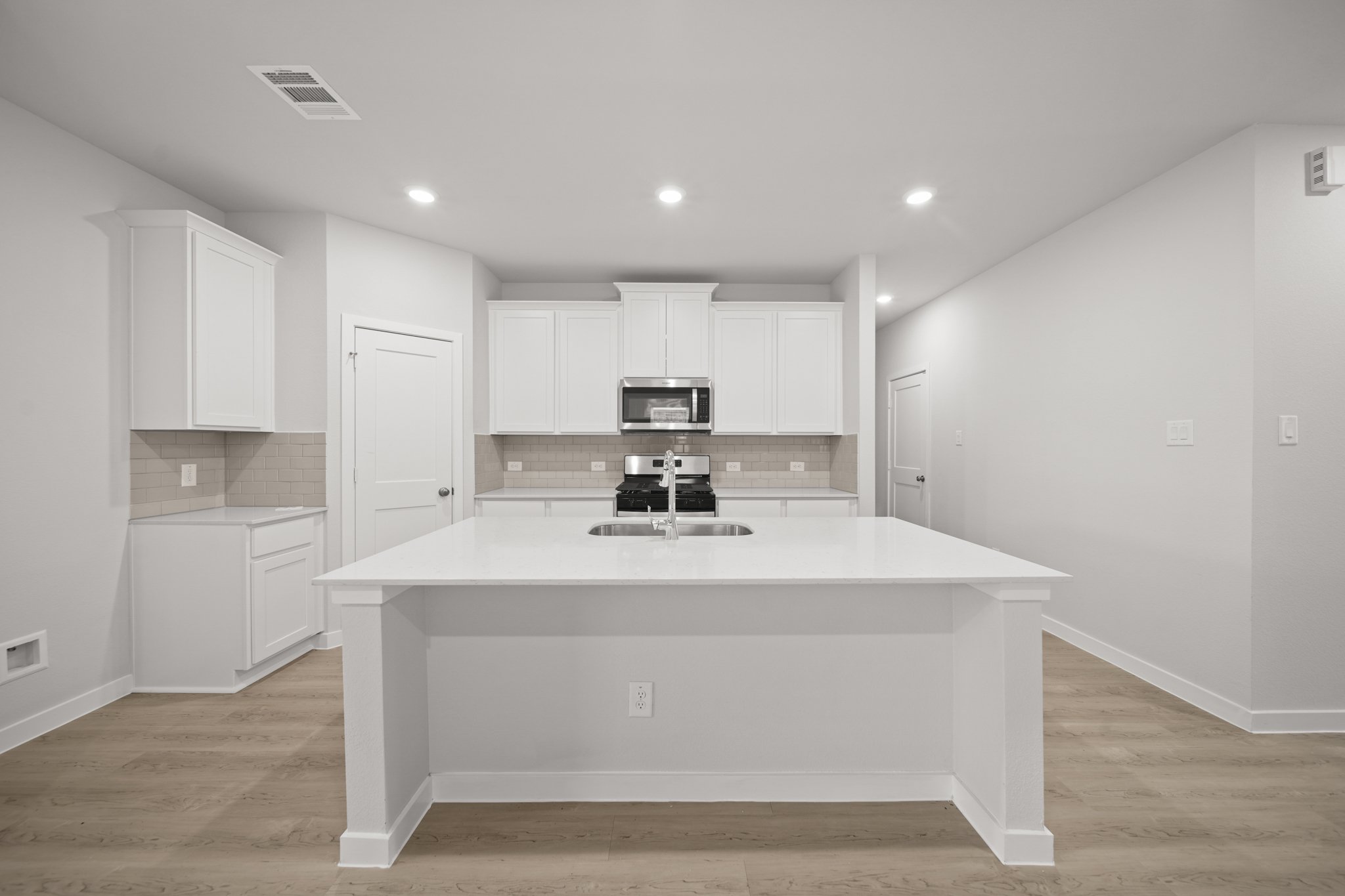 A kitchen with white cabinets.