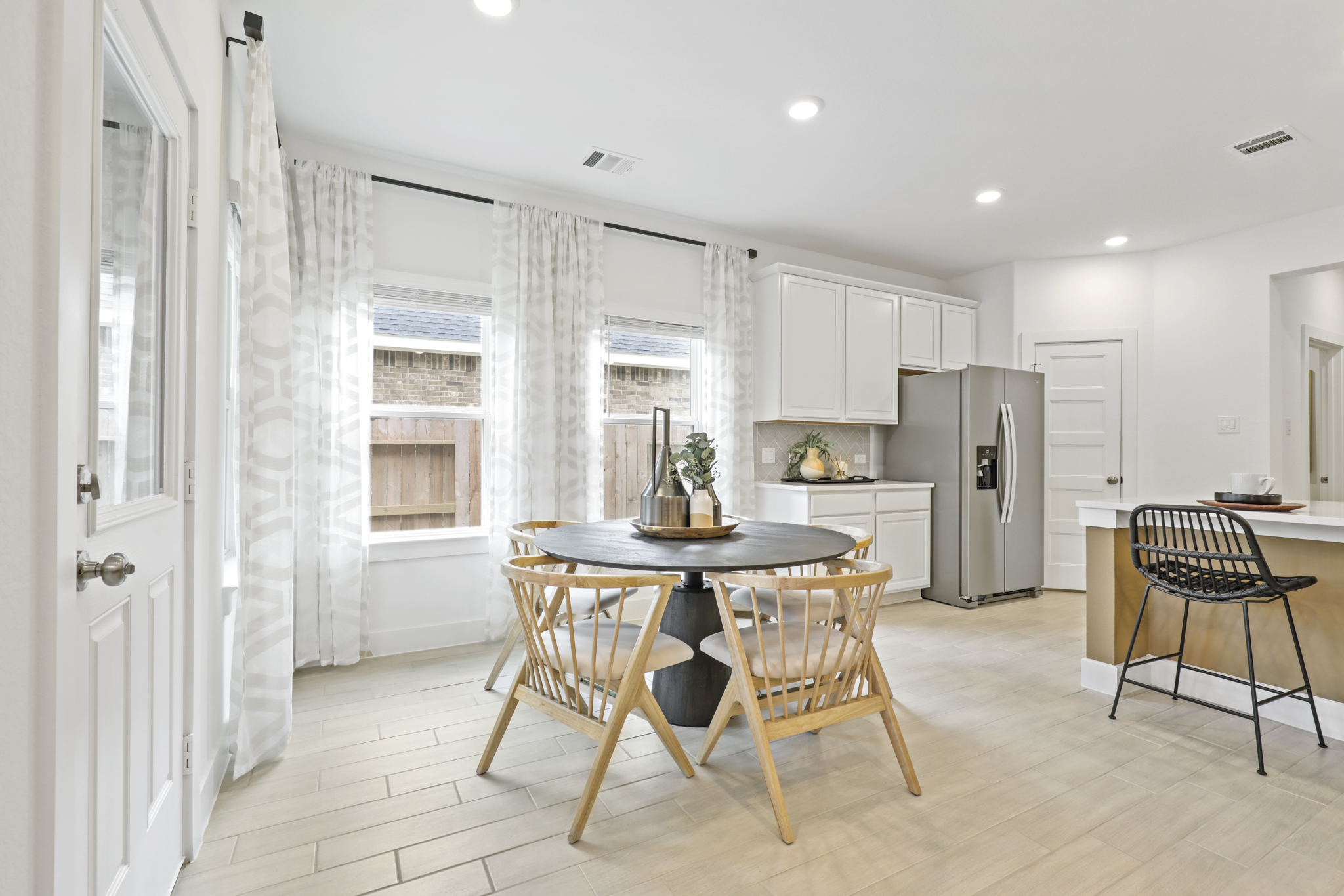 A kitchen with a table and chairs.