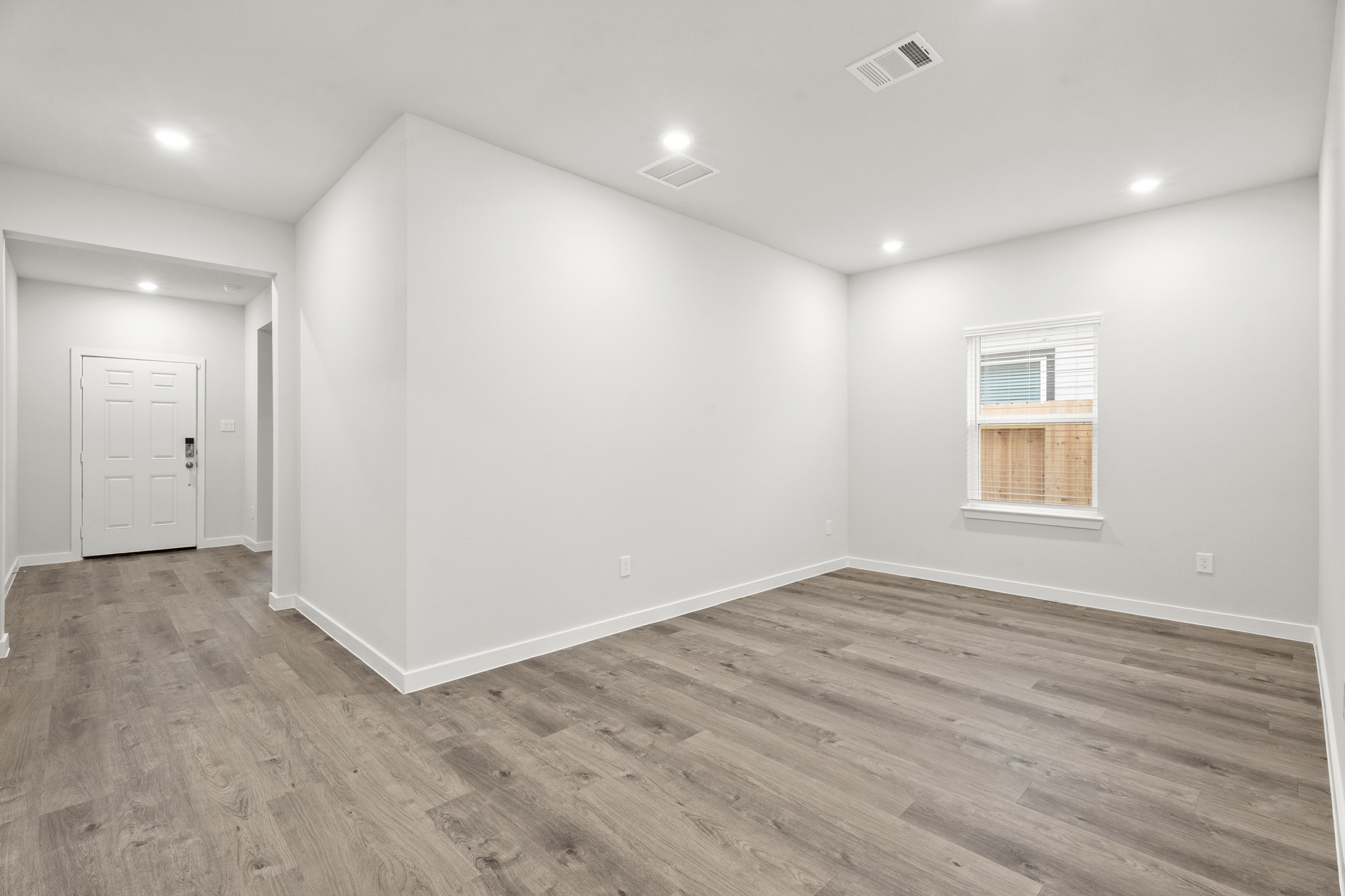 A room with a wood floor and a white door.