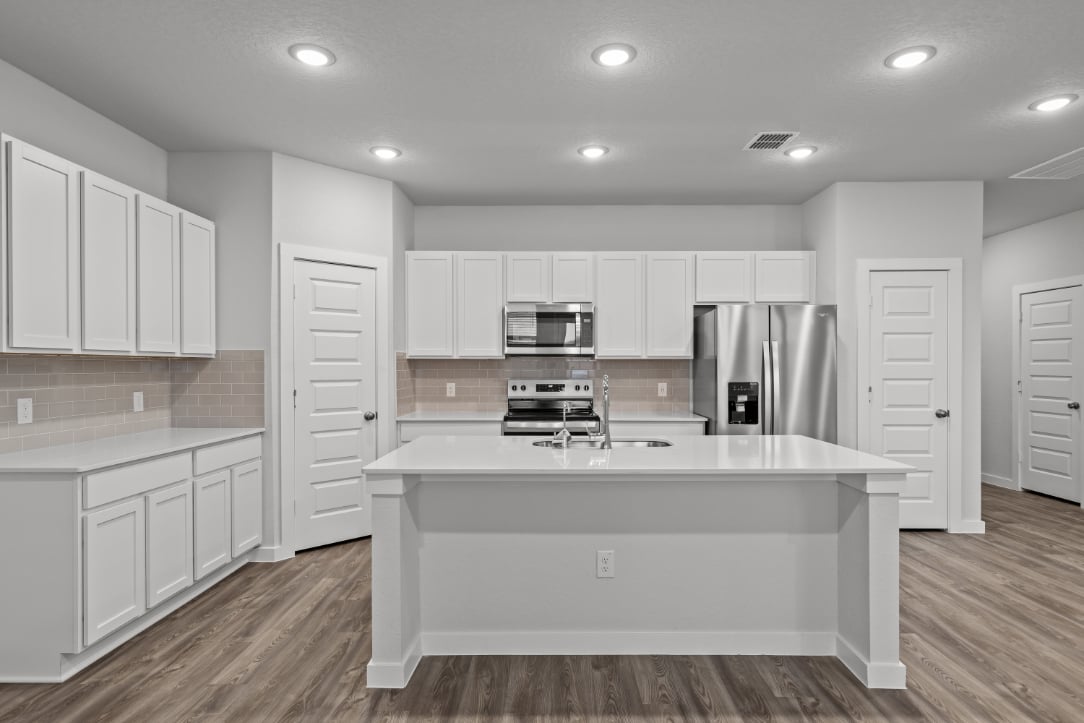 A kitchen with white cabinets.