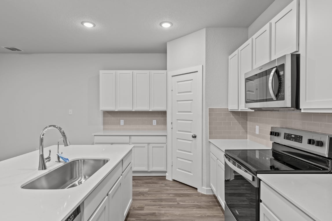 A kitchen with white cabinets.