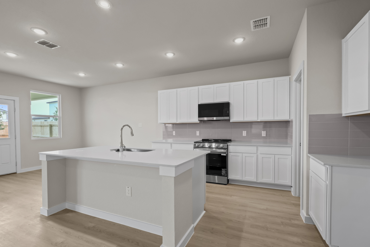 A kitchen with white cabinets.