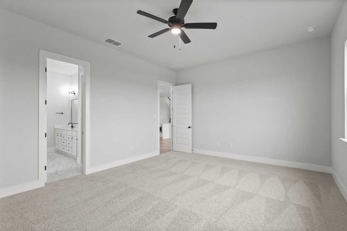 A room with a ceiling fan and a door.