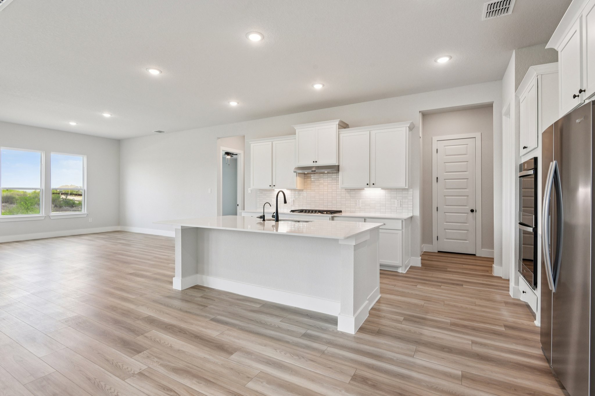 A kitchen with white cabinets.