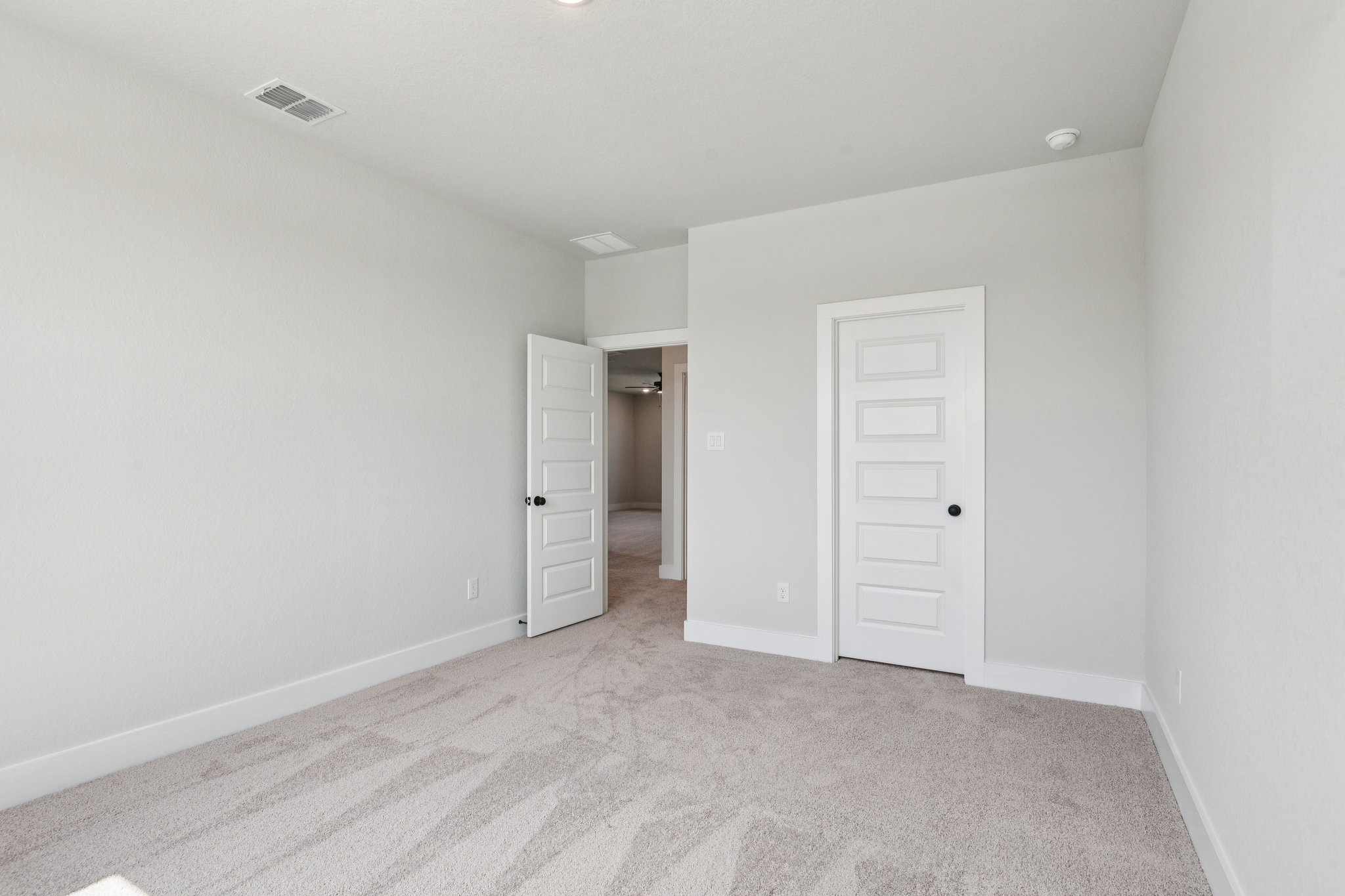A hallway with white doors.