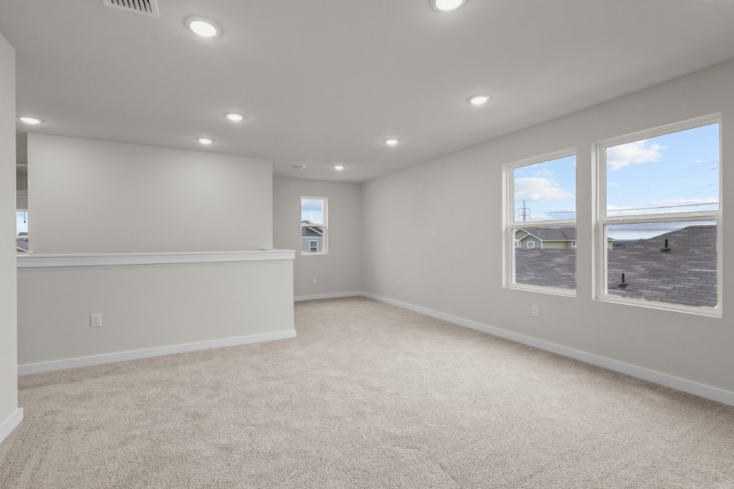 A room with a large window and a carpeted floor.