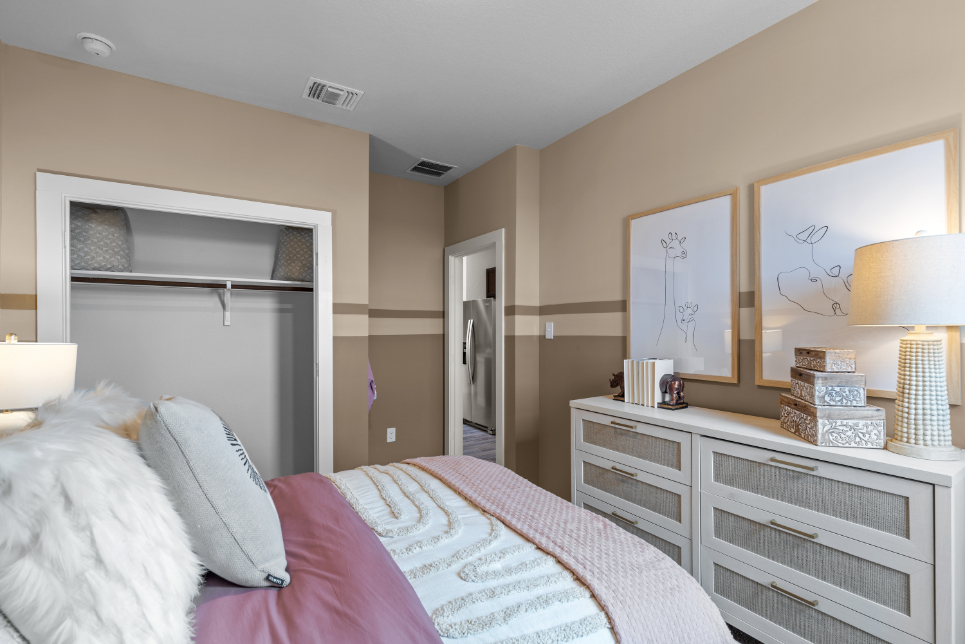 A bedroom with a bed and a dresser.