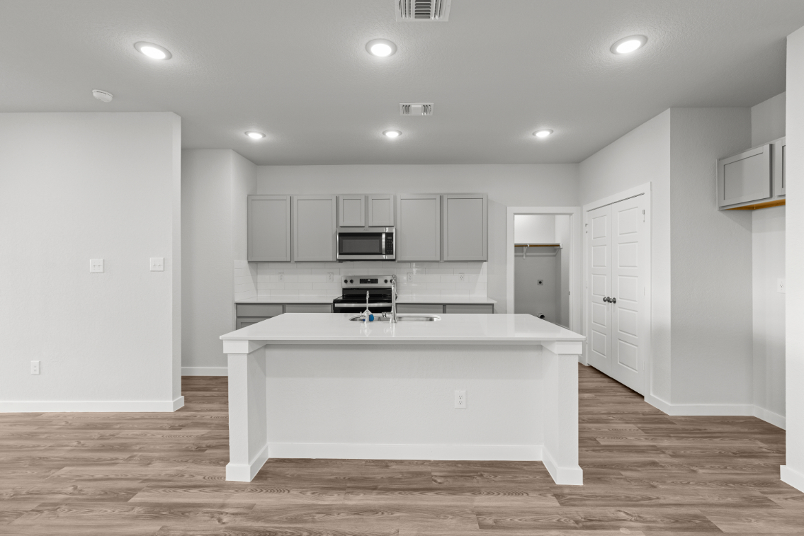 A kitchen with white cabinets.