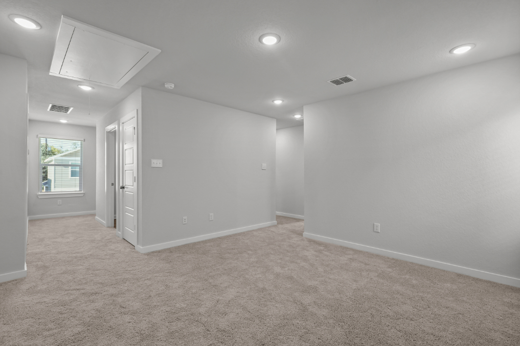 A room with a white wall and a window.