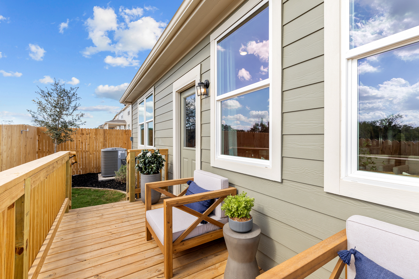 A deck with a table and chairs and a window with a view of the ocean.