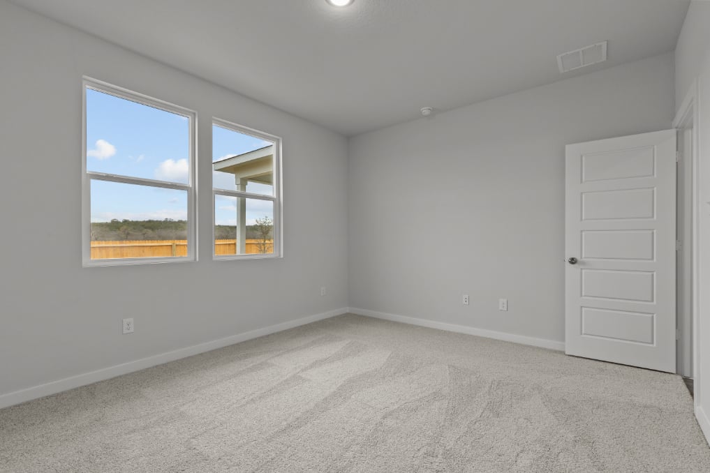 A room with a window and a door with a view of the water.