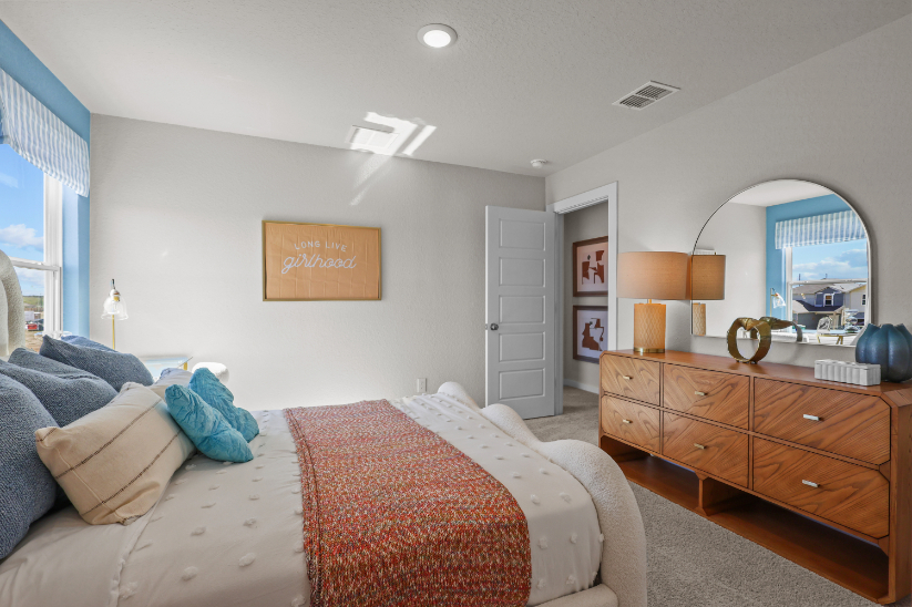 A bedroom with a large mirror.