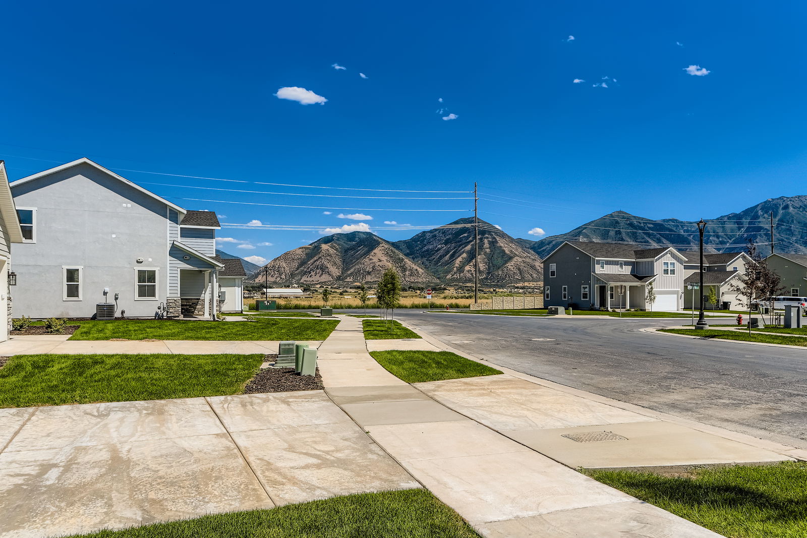 A road with houses and mountains in the background.
