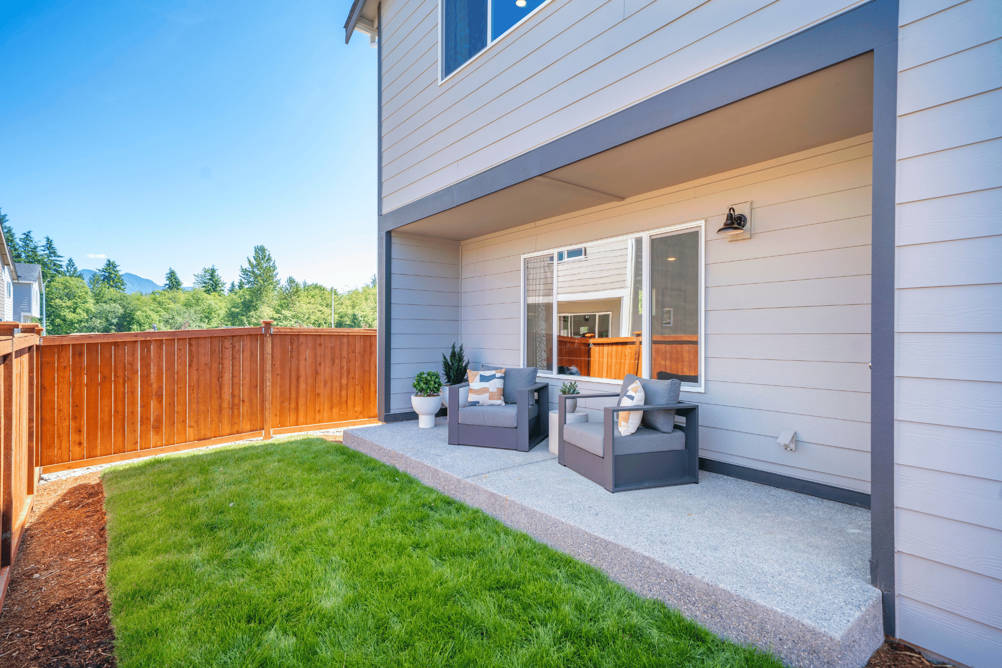 A house with a deck and a dog sitting on a bench.