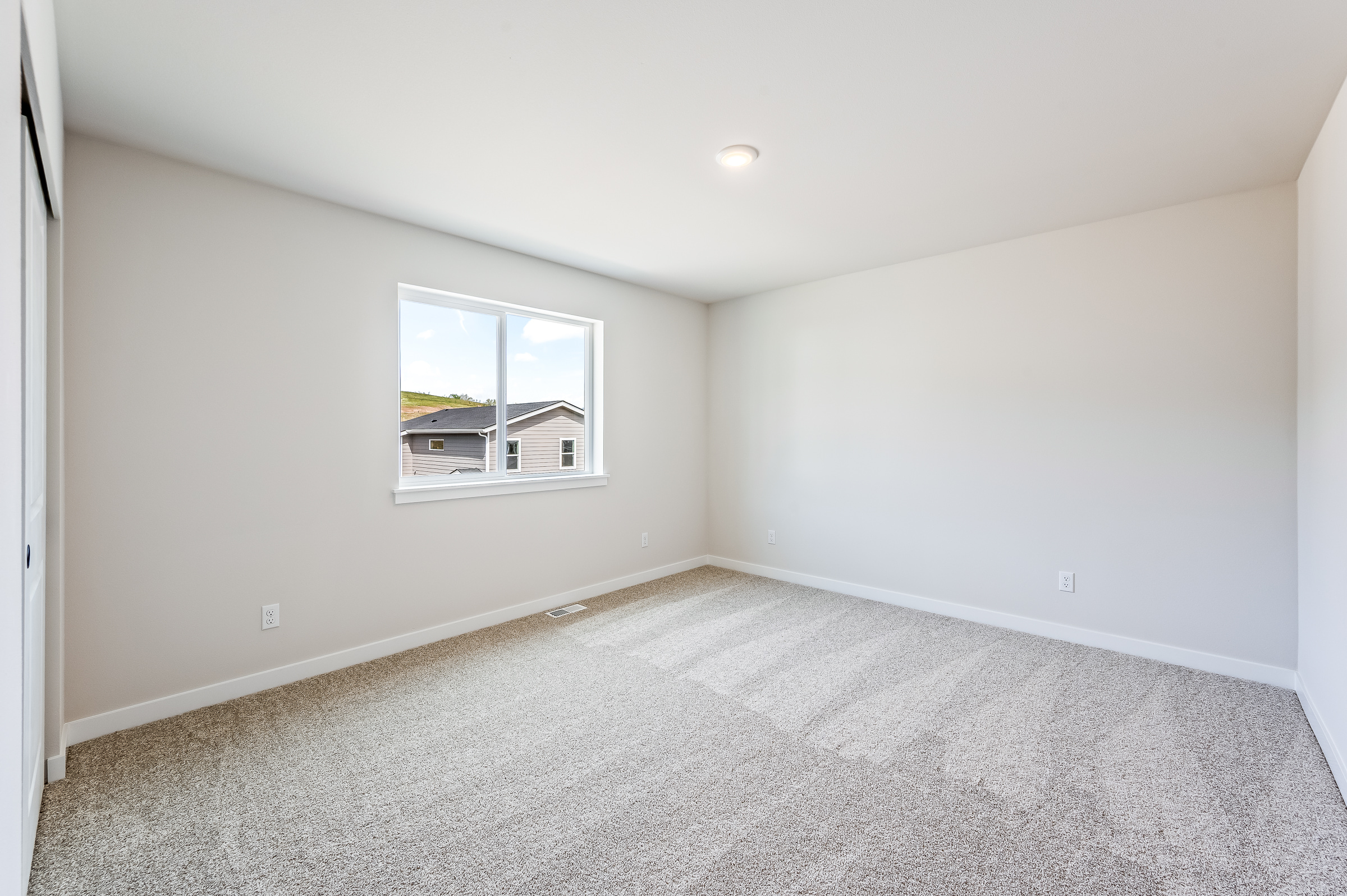 A room with a window and a carpet.