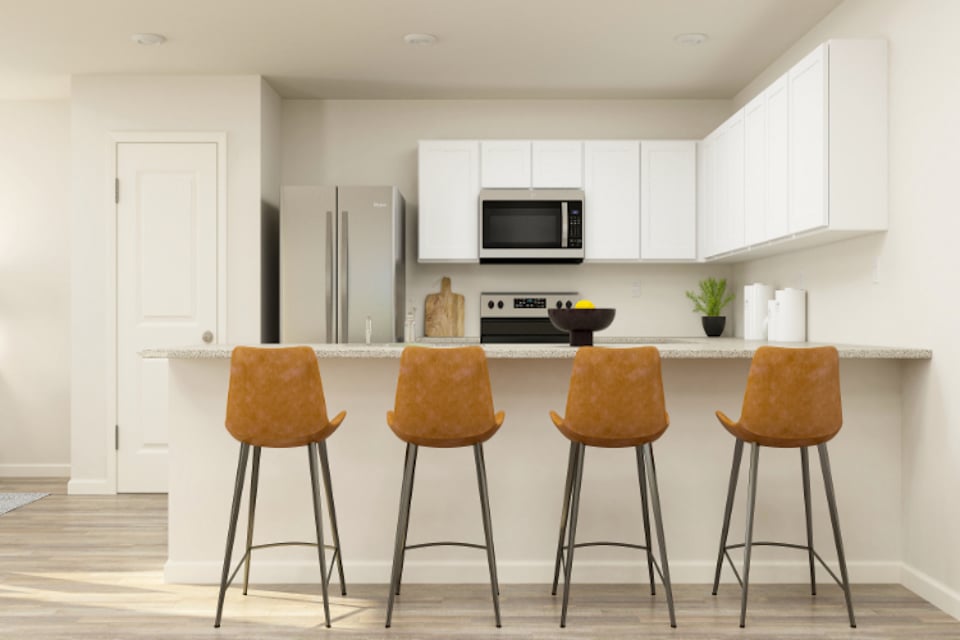 A kitchen with a table and chairs.