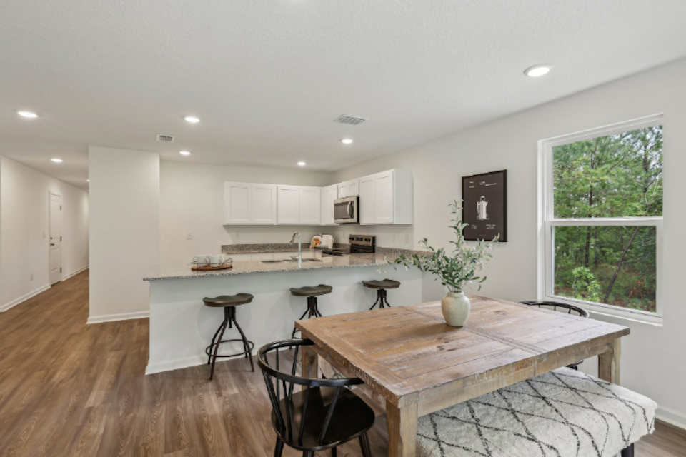 A kitchen with a table and chairs.