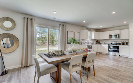 A kitchen with a dining table and chairs.