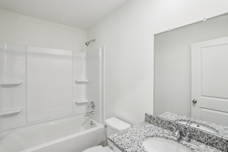 A bathroom with a tub sink and toilet.