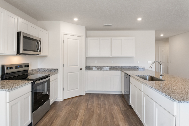A kitchen with white cabinets.