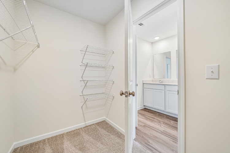 A white room with a white door and a white shelf.
