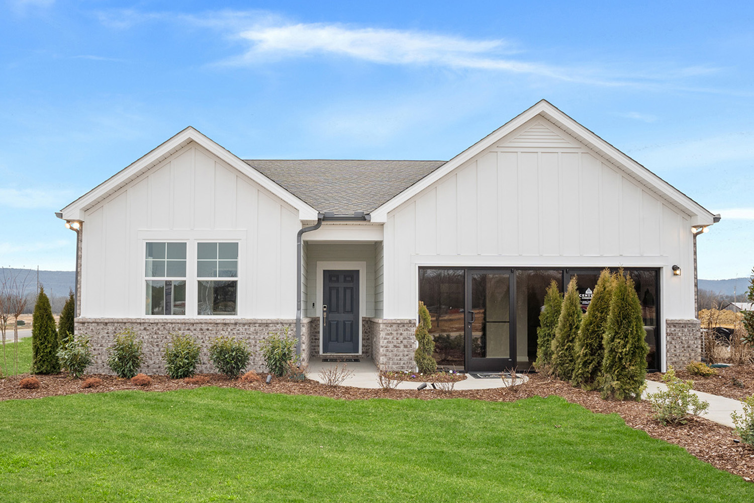 A house with a large front yard with Southfork Ranch in the background.