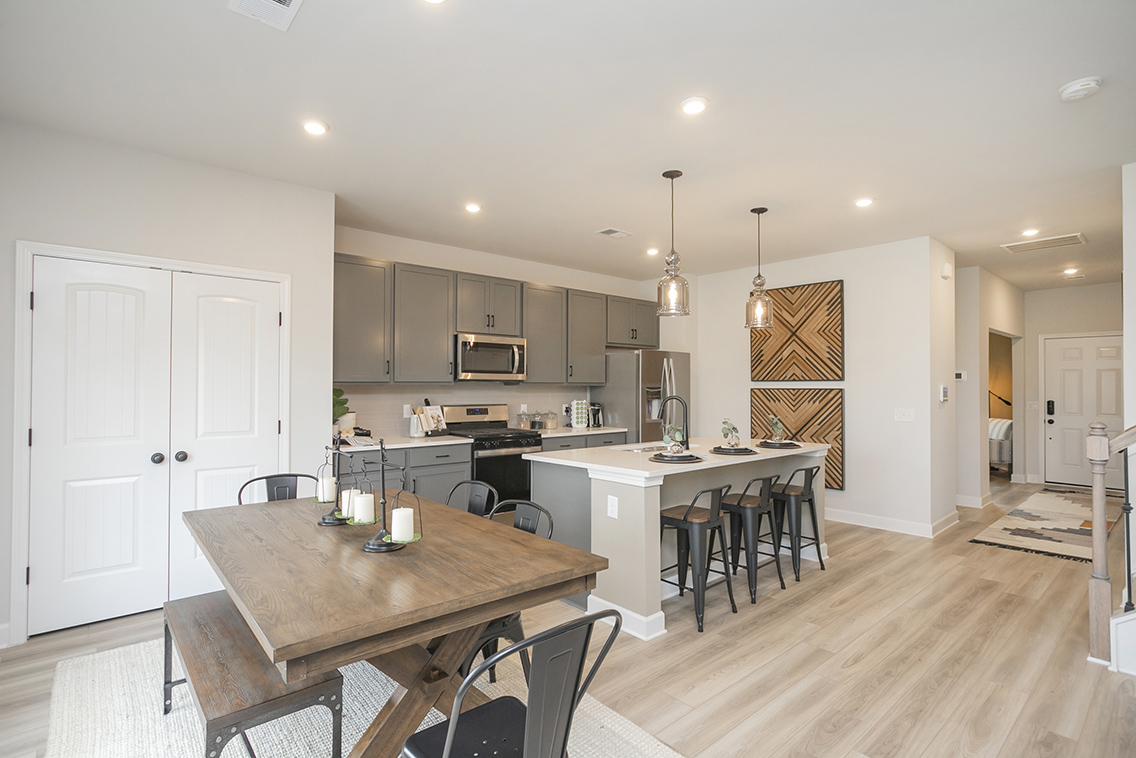 A kitchen with a dining table and chairs.