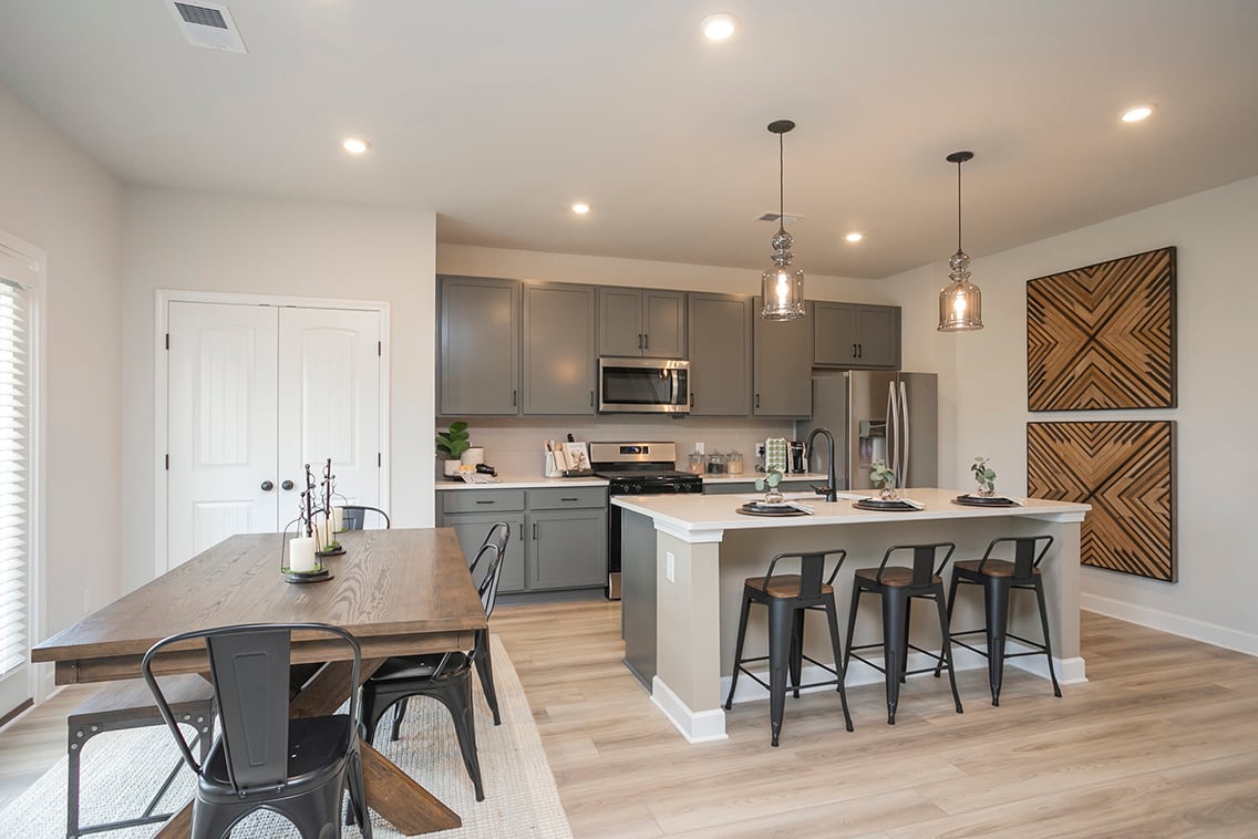 A kitchen with a table and chairs.