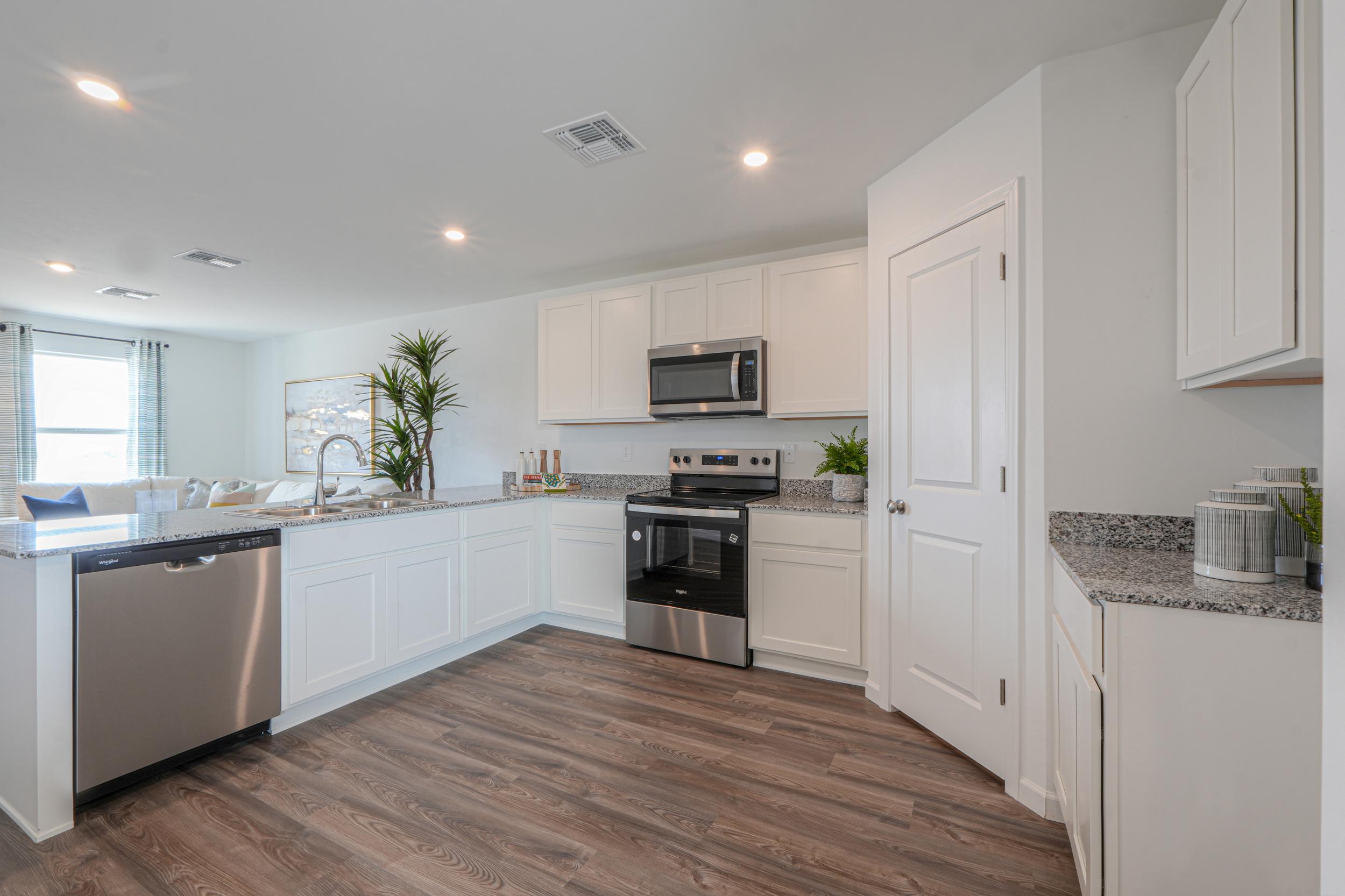 A kitchen with white cabinets.