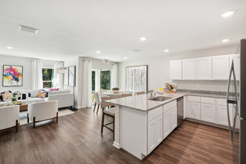 A kitchen with white cabinets.