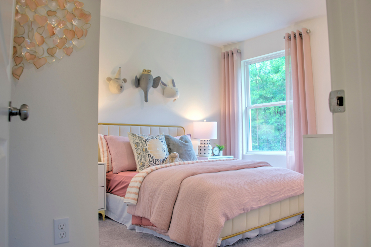 A bedroom with a pink bed.