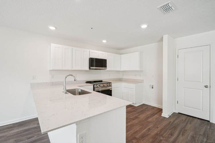 A kitchen with white cabinets.