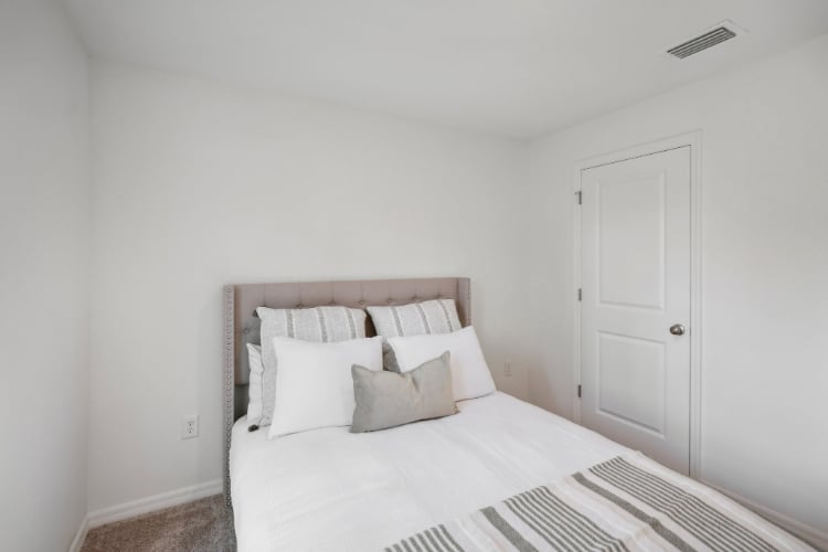 A bed with white sheets.