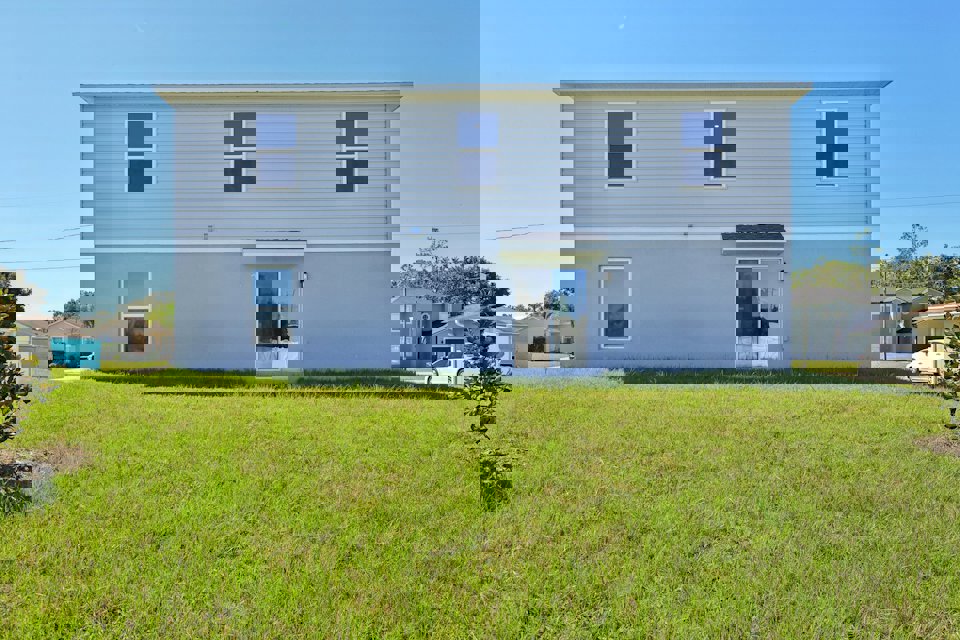 A white house with a green lawn.